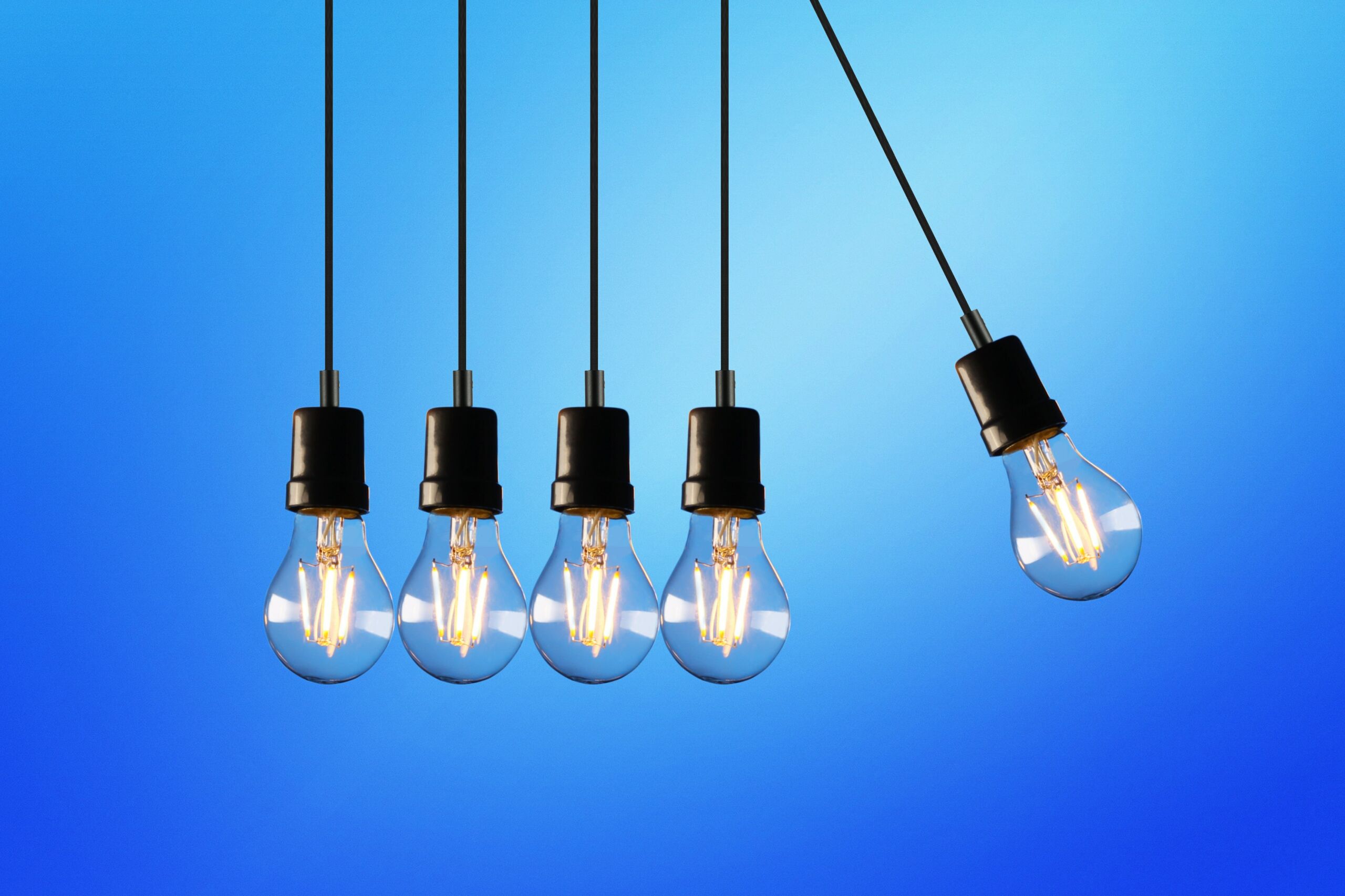 IT-Trends: 5 Glühbirnen hängen nebeneinander, wie ein Kugelstoßpendel.